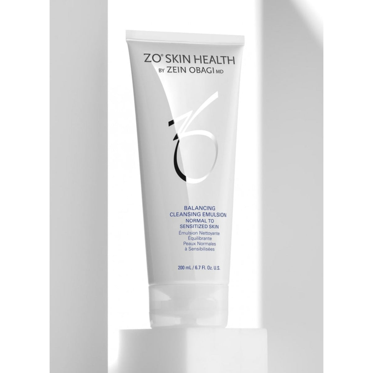 ZO Skin Health by Zein Obagi MD Balancing Cleansing Emulsion in a white squeeze tube, displayed on a white pedestal against a white background with soft shadows.