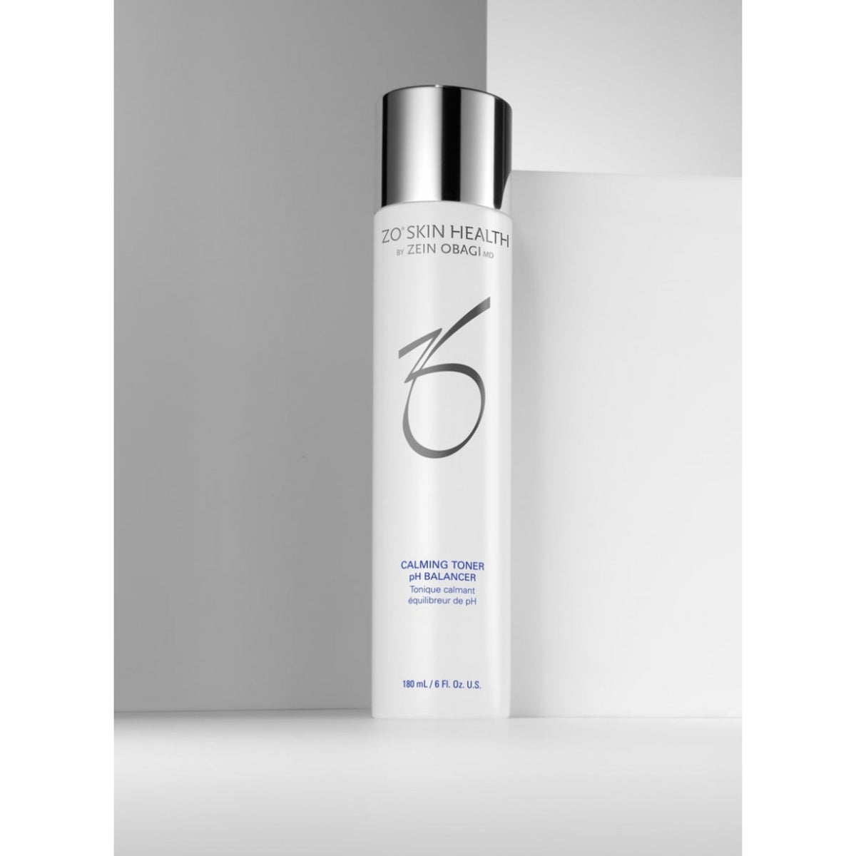 ZO Skin Health by Zein Obagi Calming Toner pH Balancer in a tall white bottle with a reflective silver cap, set against a minimalist gray background.