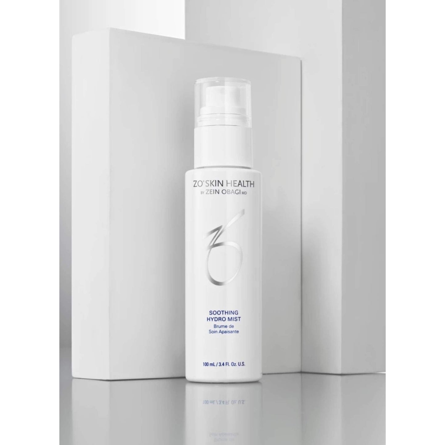 ZO Skin Health by Zen Organs Soothing Hydro Mist in a white pump bottle, displayed in front of its white packaging box on a reflective gray surface.