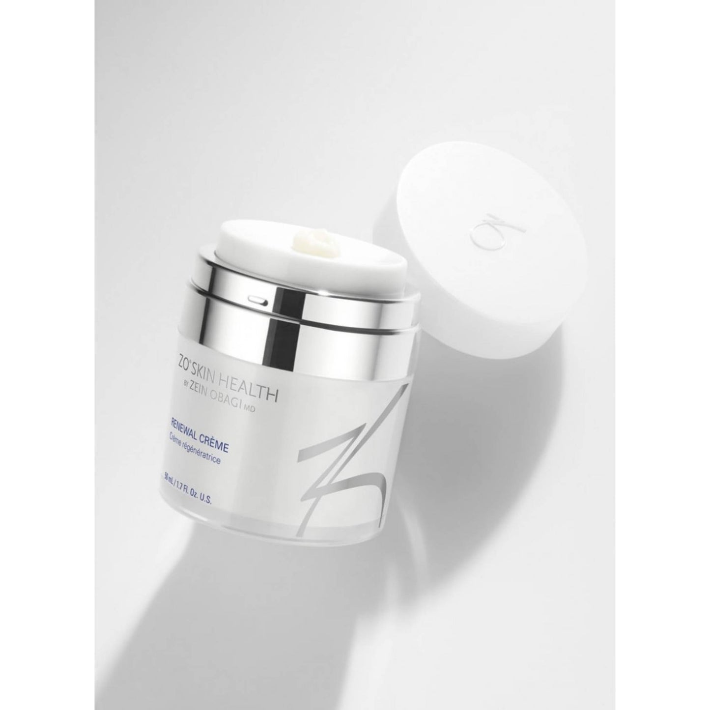 ZO Skin Health Renewal Creme in a clear jar with a silver metallic collar and a white lid leaning against it, set against a clean white background.