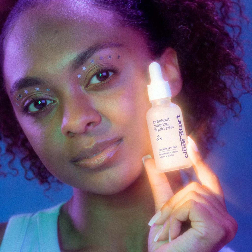 Person holding a breakout clearing liquid peel with a purple and blue filter
